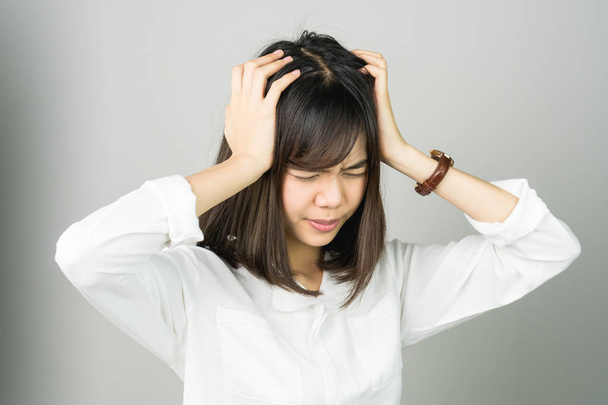 Femme en robe blanche touche la tête pour montrer son mal de tête. Les causes peuvent être causées par le stress ou la migraine. Ou parce que trop de travail. Le concept de stress dû au travail acharné est mauvais pour la santé
. - Photo, image