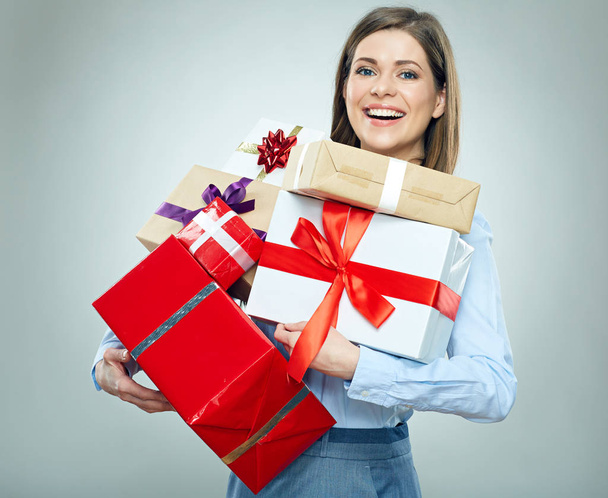 Smiling businesswoman in business clothes holding pile of gift boxes  - Foto, immagini