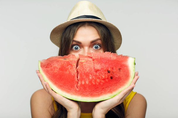 smiling woman in hat holding big slice of watermelon against face - Photo, image