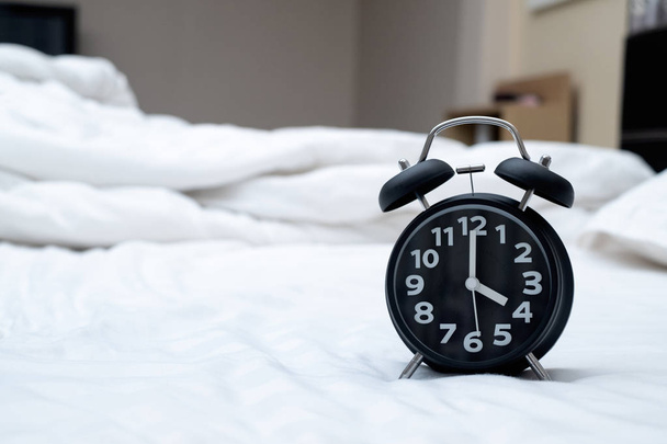 Reloj despertador vintage en la cama en el dormitorio en casa, despierta o sé
 - Foto, imagen