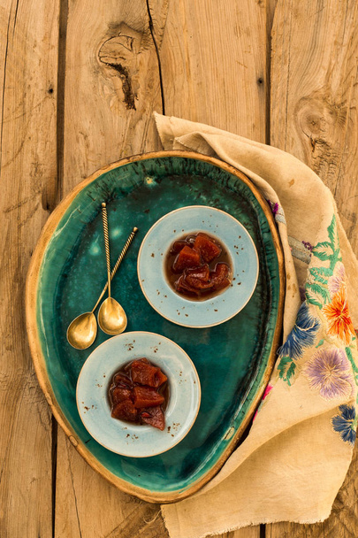 Upper view shot of quince jam in small blue ceramic plates on rustic wooden tabletop. - Photo, Image
