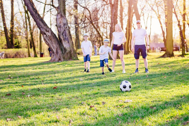 家族は公園でサッカーをプレイ. - 写真・画像