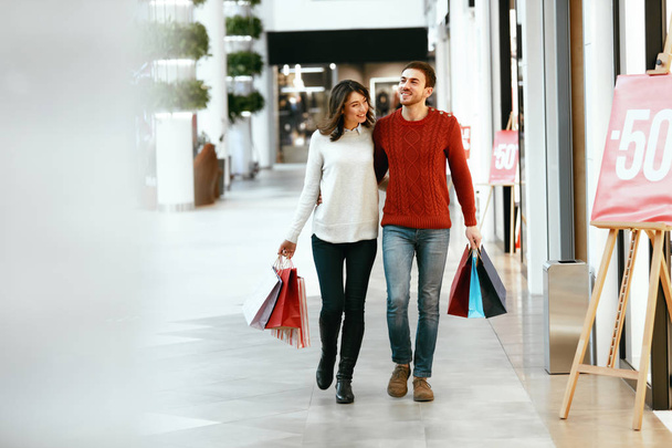 Couple Shopping. Happy Man And Woman With Bags - Фото, изображение