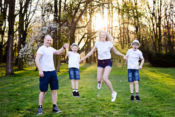 Familie springen in park. - Foto, afbeelding