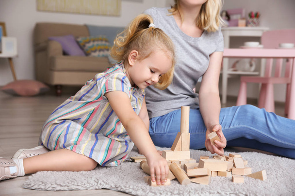 Mother and cute little girl playing with building blocks at home - Фото, зображення