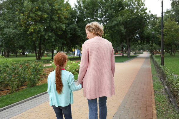 Senior woman with grandchild walking in park - Zdjęcie, obraz