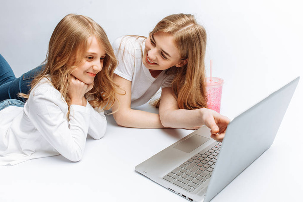 Sister or mom watching with daughter movie, or shopping online, Studio, isolated - Photo, Image