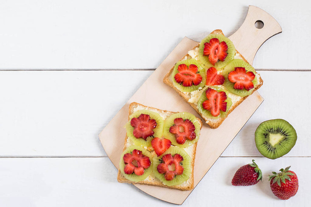 Toast with cream cheese, kiwi and strawberries in form of flower - Foto, Bild