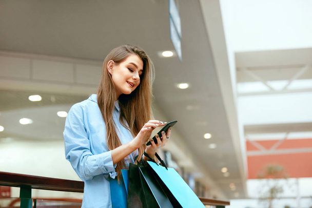 Shopping. Smiling Woman Using Phone In Shopping Centre - Foto, Bild