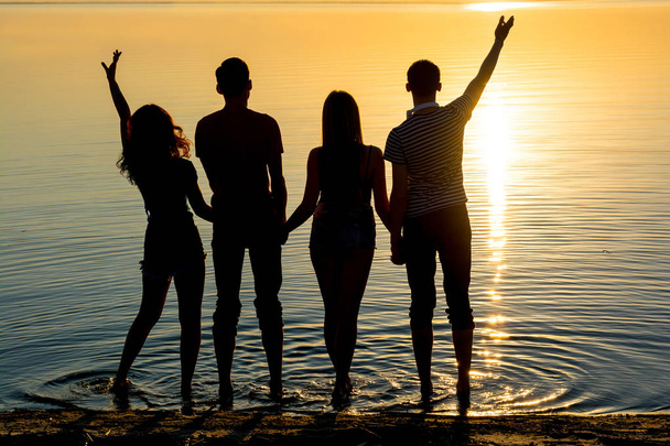 Νεαρά άτομα, αγόρια και κορίτσια, οι μαθητές στέκονται στην παραλία - Φωτογραφία, εικόνα