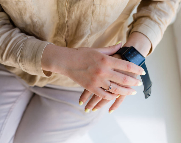 Woman holding a smartwatch - Valokuva, kuva