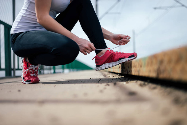 Close up view of female runner tying shoelace, crop - Photo, Image