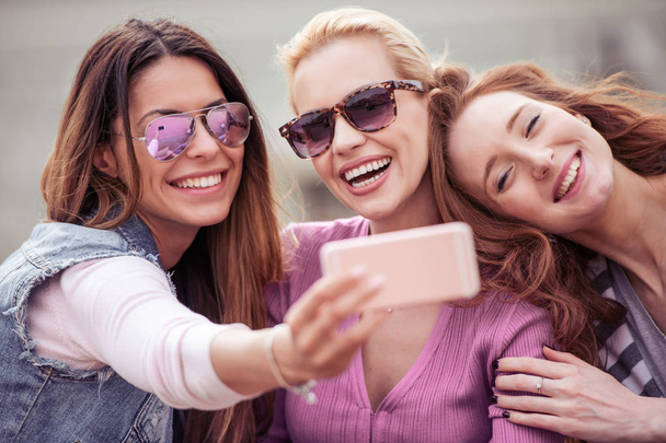 Amigos levando selfie ao ar livre.Pessoas, diversão, felicidade e estilo de vida conceito
. - Foto, Imagem