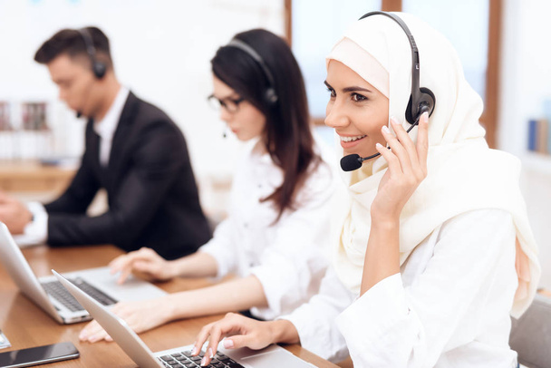 Arab woman and her colleagues working operators in call center - Foto, afbeelding