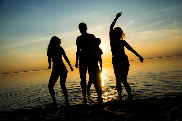 Νεαρά άτομα, αγόρια και κορίτσια, φοιτητές χορεύουν στην παραλία  - Φωτογραφία, εικόνα