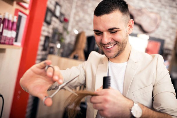Positive professional hairdresser working at the beauty salon - Foto, Imagem