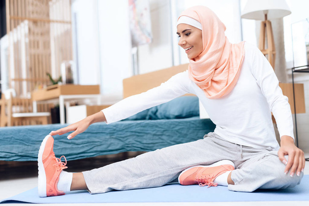 Arab woman doing gymnastics in bedroom - Valokuva, kuva