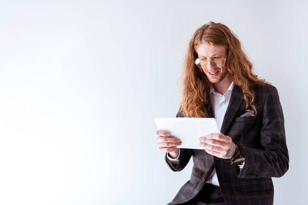 hombre de negocios con estilo con el pelo rizado utilizando tableta aislada en blanco
 - Foto, imagen