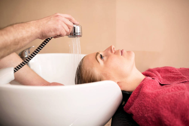 Όμορφη γυναίκα να πάρει μαλλιά πλύνετε σε ένα κομμωτήριο - Φωτογραφία, εικόνα