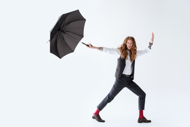 beyaz izole siyah şemsiye ile eğleniyor kıvırcık saçlı yakışıklı işadamı - Fotoğraf, Görsel