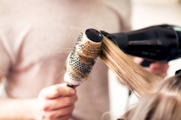 Working with comb and hair dryer at beauty salon - Photo, image