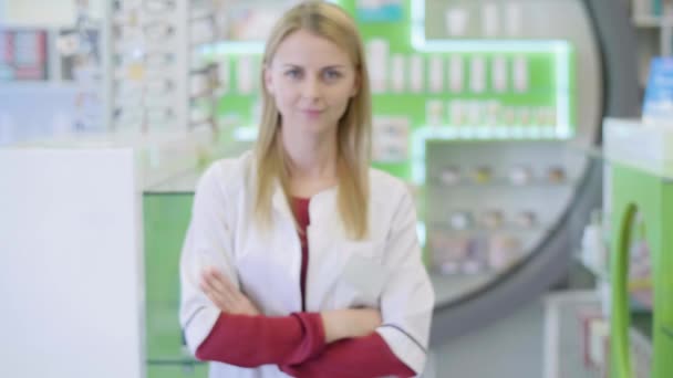 Όμορφη φαρμακοποιού στο φαρμακείο βλέπουν τα φωτογραφικών μηχανών χαμογελώντας - Πλάνα, βίντεο