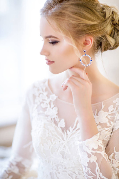 Молода красива блондинка позує у весільній сукні
  - Фото, зображення