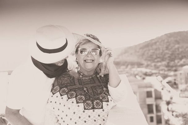 coppia vintage con cappello sorridono e si coccolano all 'aria aperta in terrazza in estate
 - Фото, изображение