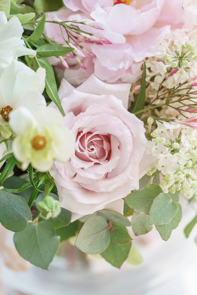 Wedding bouquet of white lilac, roses, peony and buttercup. Lots of greenery, modern asymmetrical disheveled bridal bunch. Spring flowers - Photo, Image