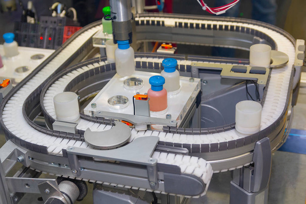 Robô trabalha em um transportador para a produção de medicamentos. Indústria
 - Foto, Imagem