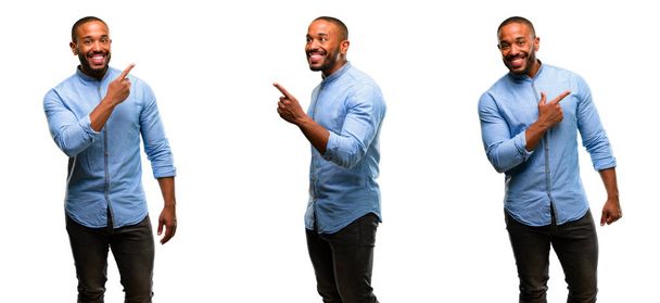 Hombre afroamericano con barba apuntando hacia un lado con el dedo
 - Foto, Imagen