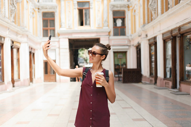Feltartotta a smartphone, figyelembe véve a selfies gyönyörű fiatal turista nő portréja - Fotó, kép