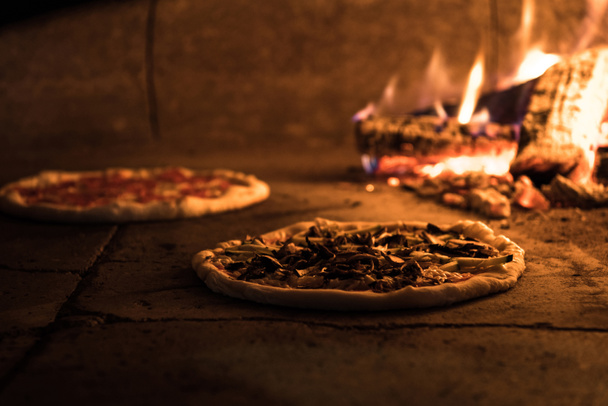 close up view of italian pizza baking in brick oven in restaurant - Photo, Image