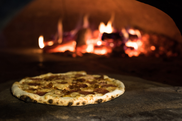 close up view of italian pizza baking in brick oven in restaurant - Foto, Bild