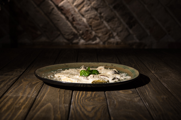 close up view of italian dish on plate on wooden surface - Photo, image