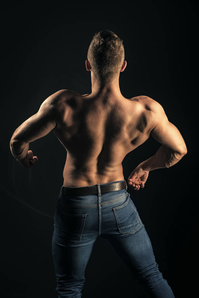 Sportsman show muscles on dark background - Foto, Imagem