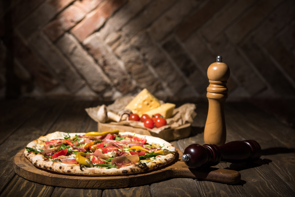 centre sélectif de pizza italienne, épices, tomates cerises et fromage sur table en bois
 - Photo, image