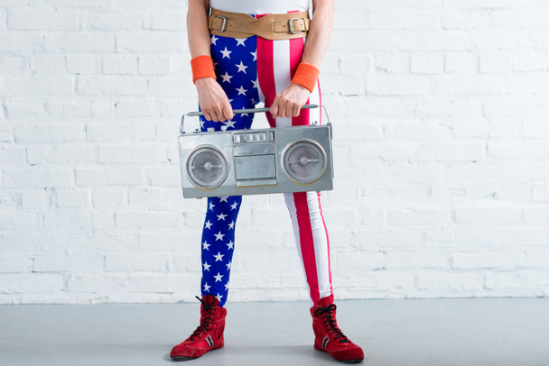 tiro recortado de mujer mayor en ropa deportiva patriótica celebración grabadora de cinta
 - Foto, imagen