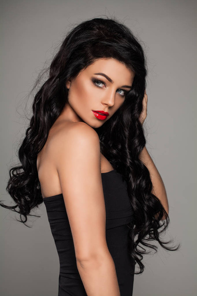 Modelo de moda de mulher sexy com cabelo ondulado escuro e maquiagem de lábios vermelhos
 - Foto, Imagem