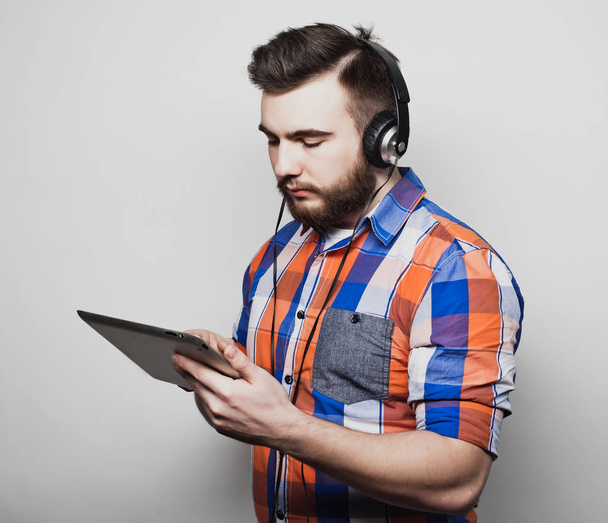 Lifestyle, people and education concept:  man listening to audiobook through headphones on white background. - Foto, Imagen