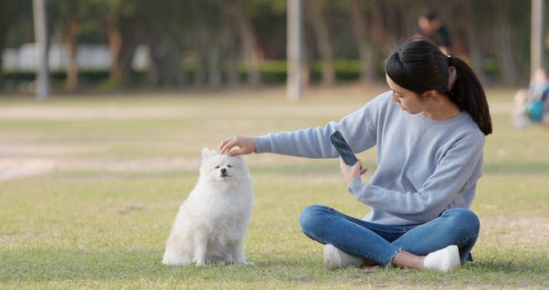Woman taking photo with her dog  - 写真・画像