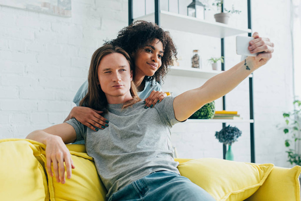 young interracial couple taking selfie on smartphone  - Photo, Image