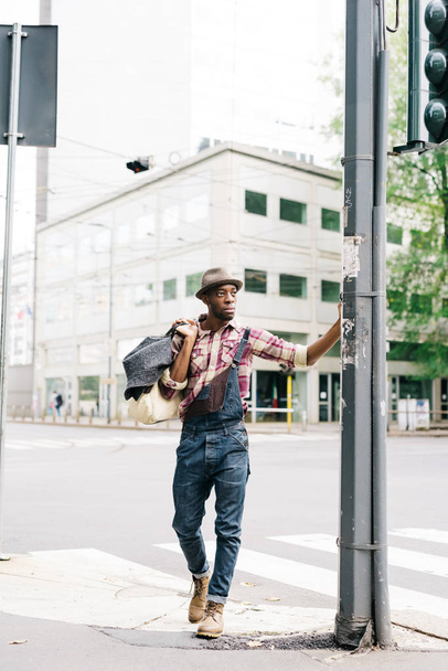 молодой красивый африканский мужчина, гуляющий по городу
  - Фото, изображение