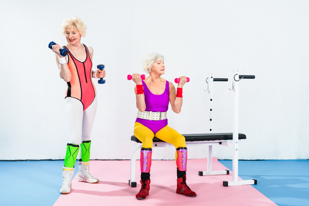 спортивні літні жінки в спортивному одязі вправи з гантелями в спортзалі
 - Фото, зображення