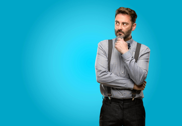 Middle age man, with beard and bow tie doubt expression, confuse and wonder concept, uncertain future - Photo, Image