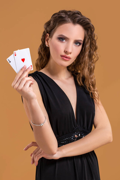 İki as poker oyunu, kumar ve casino için bir işaret olarak tutan güzel kahverengi saçlı kadın - Fotoğraf, Görsel