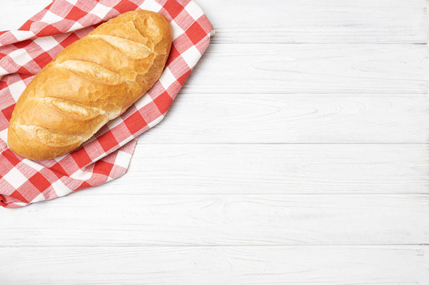 Pão fresco com guardanapo na mesa da cozinha
 - Foto, Imagem