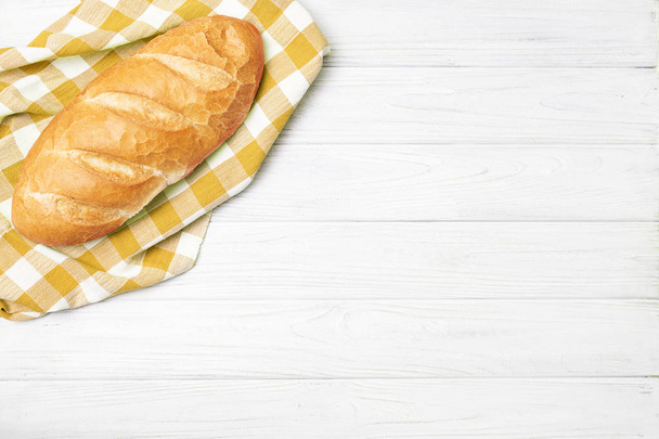 Fresh bread with napkin on kitchen table - Photo, image