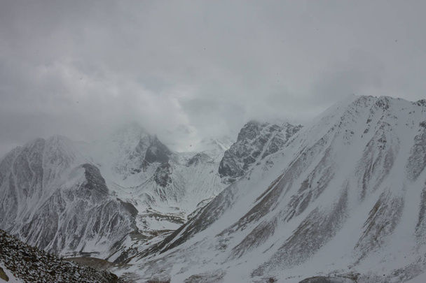 verschneite Berge Aero-Foto-Drohne, Wolken nähern sich Gipfeln und Tal - Foto, Bild