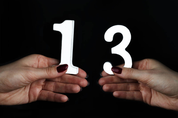 To female hands the number thirteen. - Photo, Image